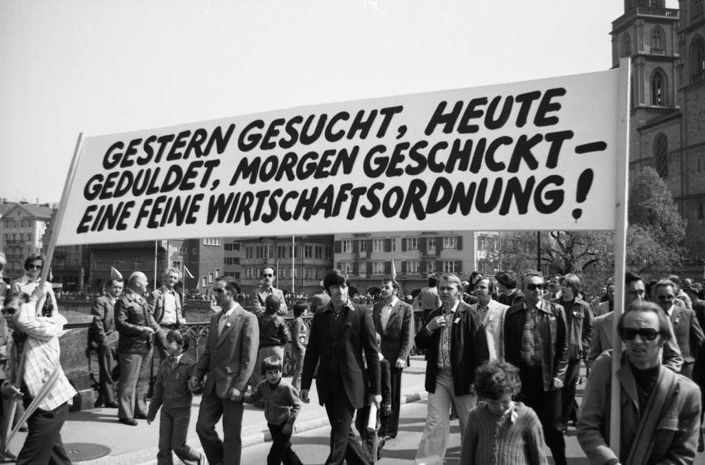 « Hier recherché, aujourd’hui toléré, demain chassé – quel système économique ! ». Défilé du 1er Mai, Münsterbrücke Zurich, 1976. Source: Archives sociales suisses, Sozarch_F_5069-Na-003-018.