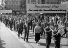 Cortège du 1er mai: manifestation avec musiciens et banderolle "Bundesrat Etter, her mit der Invalidenversicherung", 1957. Archives sociales suisses, Zurich.